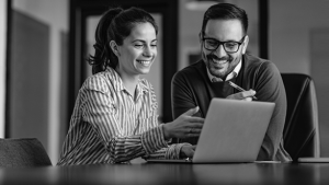 Man and woman looking at laptop while smiling